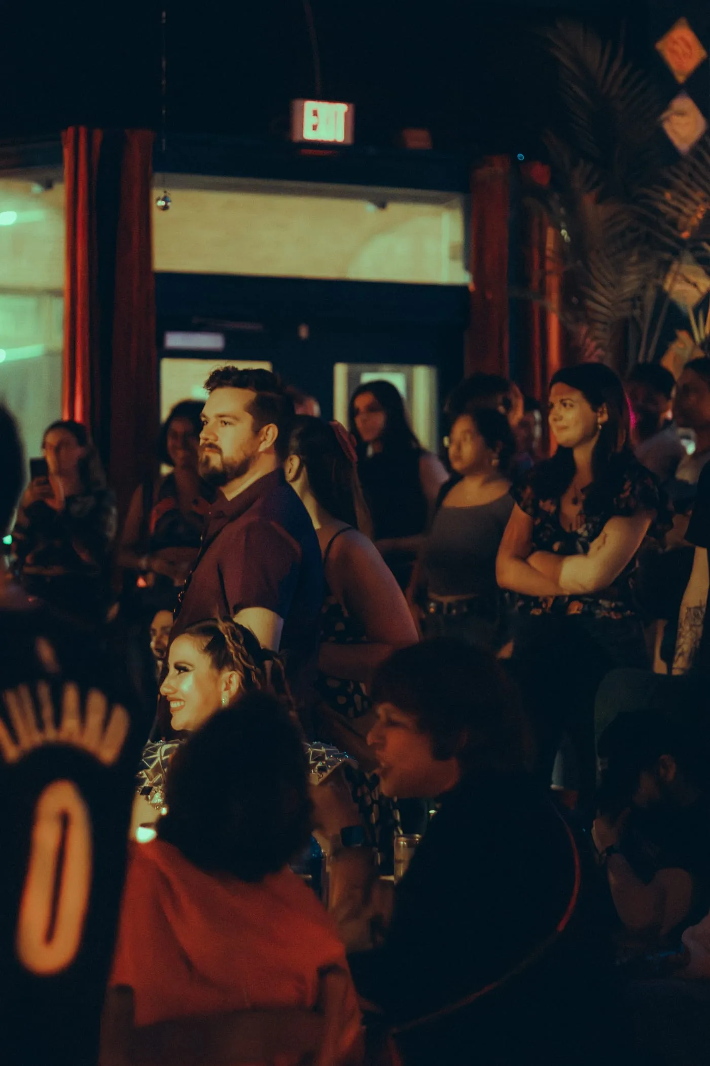 A crowd gathered close together at an evening art event